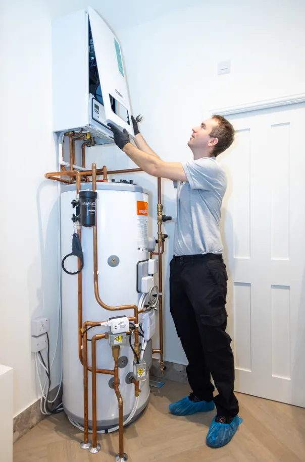 Modern wall-mounted boiler with neatly arranged pipework in a home utility room